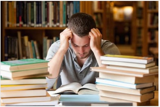 ایک پریشان طالب علم مطالعہ کتب میں مصروف