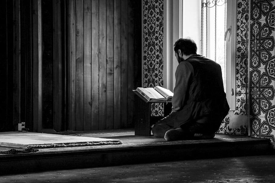 مسلمان نوجوان مسجد میں قرآن مجید پڑھتے ہوئے