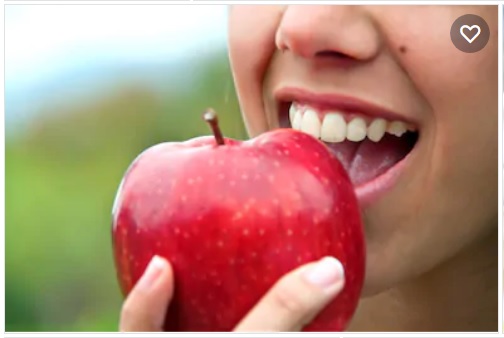 لڑکی سرخ سیب کھاتے ہوئے