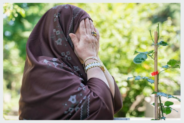مسلمان بزرگ خاتون دعا مانگنے کے بعد منہ پر ہاتھ پھیر رہی ہے