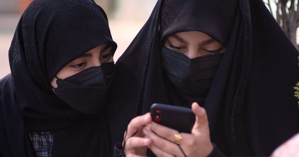 دو باحجاب مسلمان خواتین موبائل دیکھ رہی ہیں