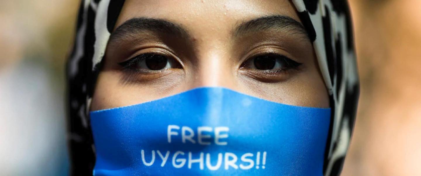 باحجاب ، ماسک پہنے ہوئے اویغور خاتون آزادی کا کتبہ اٹھائے ہوئے