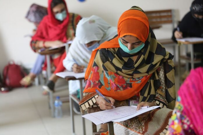 پاکستانی طالبہ کمرہ امتحان میں لکھ رہی ہے