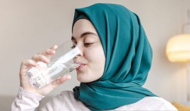 باحجاب نوجوان خاتون پانی پیتے ہوئے