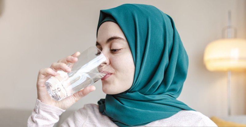 باحجاب نوجوان خاتون پانی پیتے ہوئے